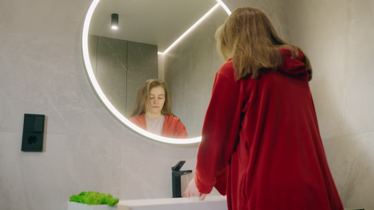 Woman washing hands in a modern bathroom