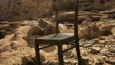 lonely wooden chair on rocky terrain near a cliff edge under bright sun