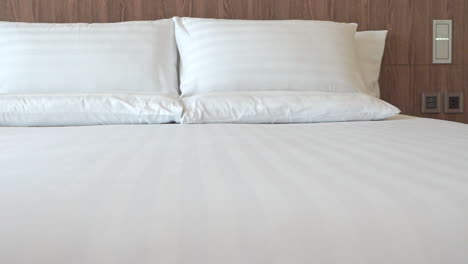 Langsamer-Schwenk-Links-Auf-Ein-Hergerichtetes-Hotelzimmer-Mit-Weißen-Kissen-Auf-Einem-Kingsize-Bett