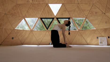 yoga poses in a zen, geometric outdoor studio with a hispanic woman embracing calmness and mindfulness, sitting on knees stretching back