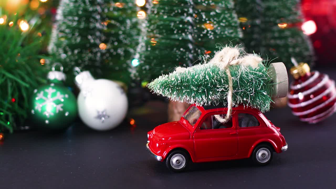 un primer plano de la decoración de invierno de navidad y un coche rojo vintage con árbol de navidad en el techo.