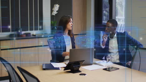 un hombre y una mujer de negocios están discutiendo y usando una computadora portátil en una oficina moderna.