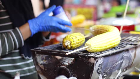 vendor grilling corn at night market stall