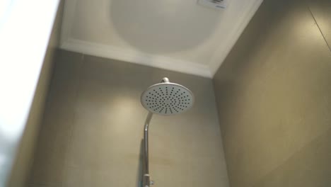 slow motion close up of the shower in a bathroom, shower head in a hotel room, luxury vacations, copy space