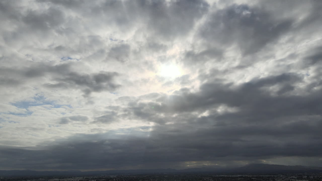 Cloudy Sky Over City with Mountains in the Distance