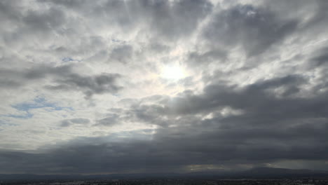 cloudy sky over city with mountains in the distance