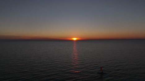 Aerial-reverse-reveal-of-sunset-over-Mobile-Bay,-Alabama