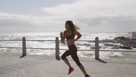 sporty caucasian woman exercising on a promenade on seaside