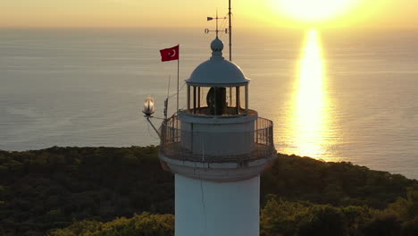 Vista-Aérea-Del-Faro-De-Gelidonya,-La-Bandera-Turca-Y-El-Horizonte-Del-Mar-Mediterráneo-Al-Atardecer