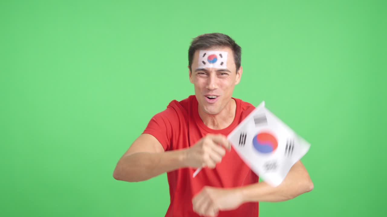 Man cheering for South Korea screaming and waving a national flag