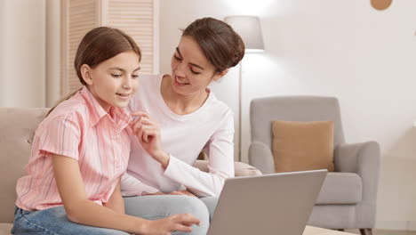 mujer y adolescente usando una computadora portátil en casa