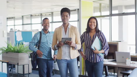 portrait of african american business people looking at camera and smiling at office, slow motion