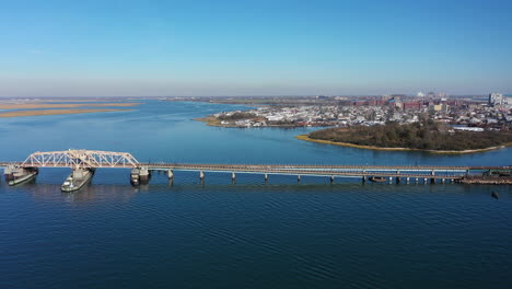 a high angle shot of an elevated train track crossing over the bay in queens, ny