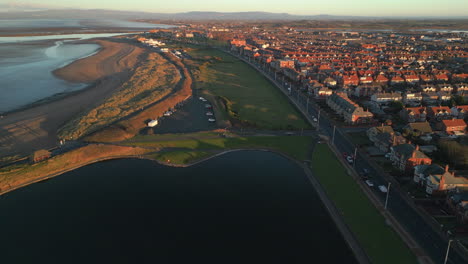 Flying-over-lake-into-urban-setting-at-sunset-Fleetwood-UK