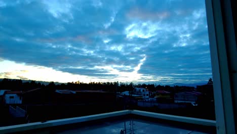 timelapse of the sky in the early morning hours with the view of the horizon and the sun shining on the clouds seen from a window in the early morning