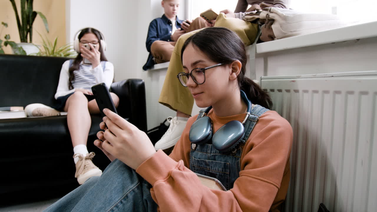 Teenagers absorbed in their smartphones in a casual setting