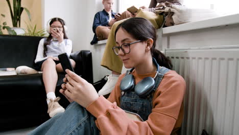 teenagers absorbed in their smartphones in a casual setting
