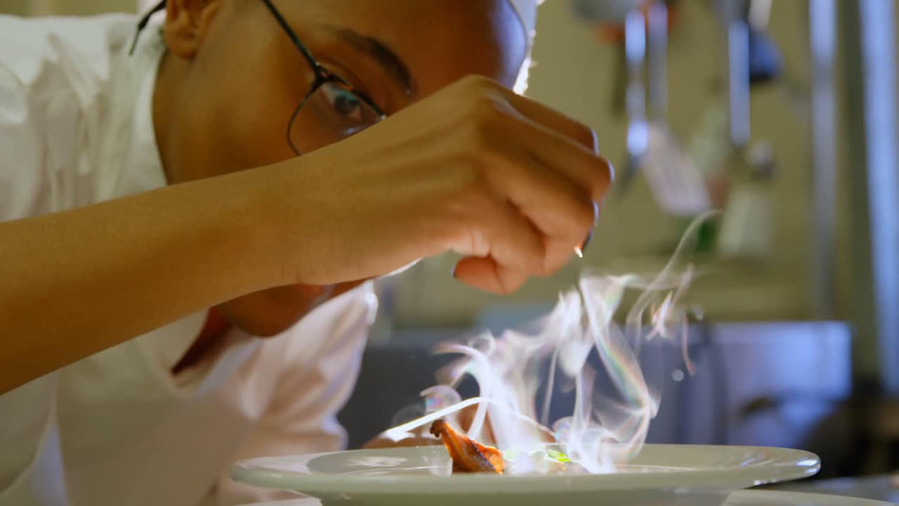 cuoco donna che addobba il cibo sul piatto in cucina 4k