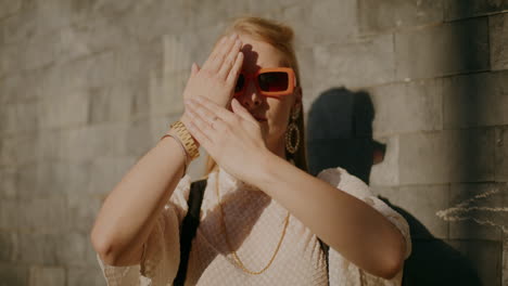 mujer posando al aire libre con gafas de sol y joyas