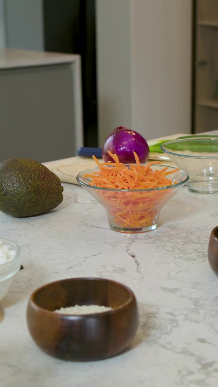 Vertical video: Panning camera showing halved purple cabbage and board on marble counter for prep