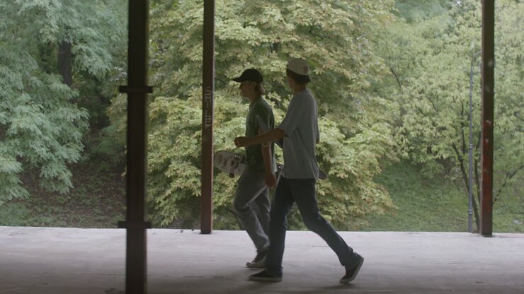 Caucasian skateboarders in a ruined building.