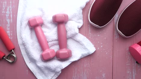 equipo de entrenamiento rosado en superficie de madera rosada