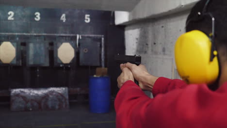 person practicing pistol shooting at a gun range