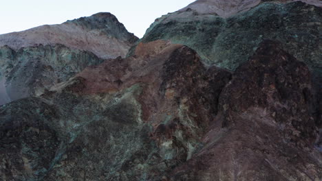 aerial shot pushes in on steep canyon walls along artist's drive in death valley national park, california