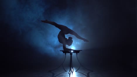 acrobat performing handstand on a table