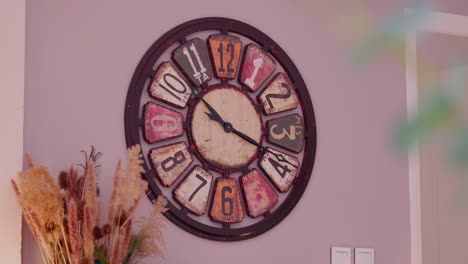 slow revealing shot of a large antique-designed wall clock hanging