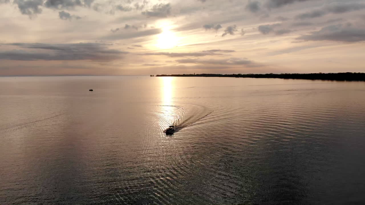 미국 미시간 주 케이즈빌에서 여름에 해가 지는 아름다운 만에서 항해하는 배의 공중 촬영