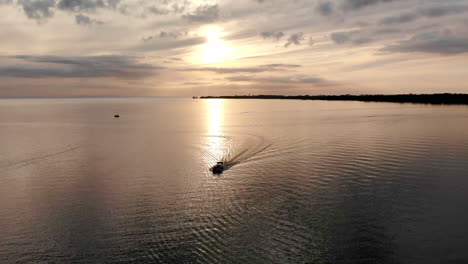 Imágenes-Aéreas-De-Un-Barco-Navegando-En-Una-Hermosa-Bahía-Al-Atardecer-Durante-El-Verano-En-Caseville,-Michigan,-EE.UU.