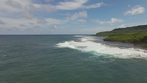 flying over the coast as waves crash on a tropical island