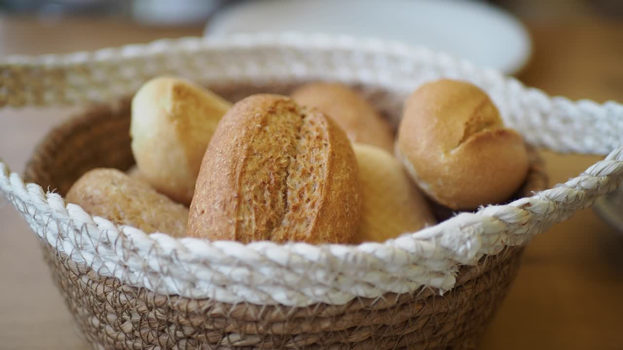Hand Picking a Fresh Bread Roll from a Woven Basket