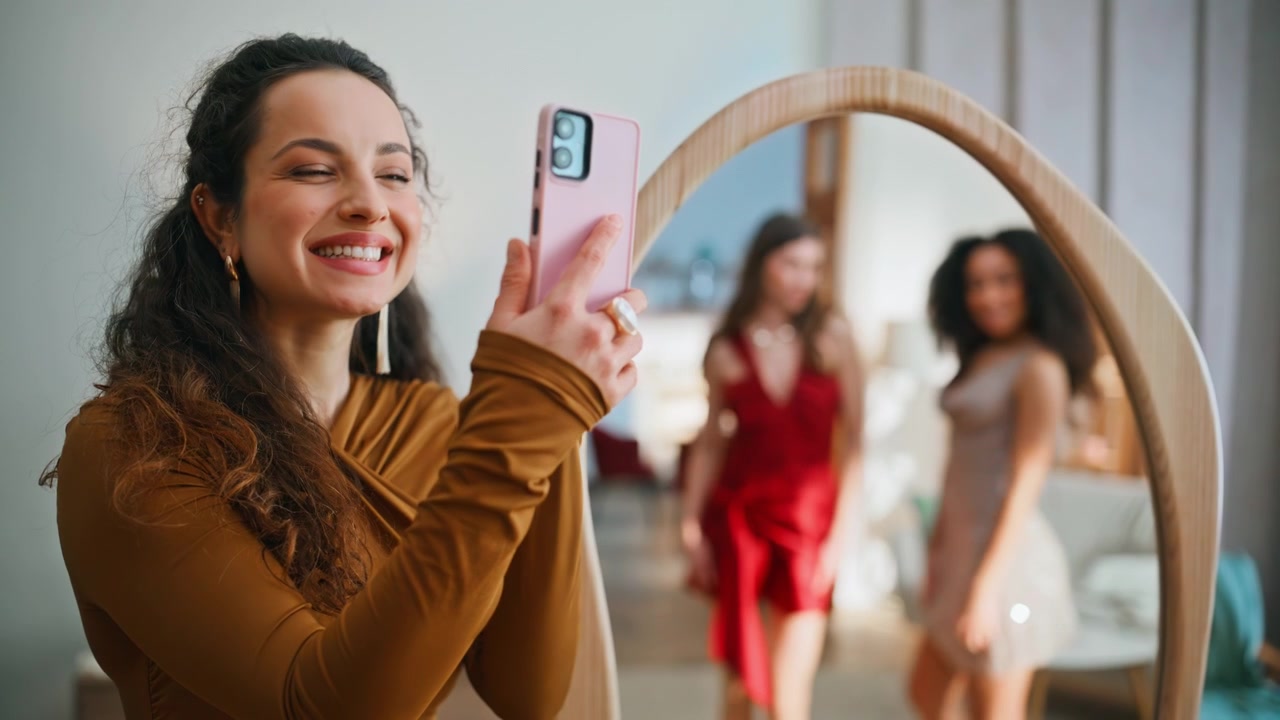 Luxury ladies admiring reflection home. Smiling brunette making cellphone photo