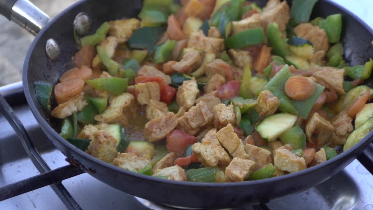 tofu vegetariano vegano cocinando chisporroteando en una sartén caliente comida para acampar