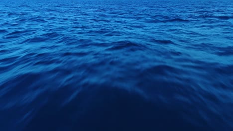 vista dall'occhio di un uccello in volo basso sopra le onde d'acqua dell'oceano e le calmanti tonalità blu