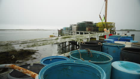 fishing equipment and lobster traps on pier looking out over ocean marina in maine 4k 60p