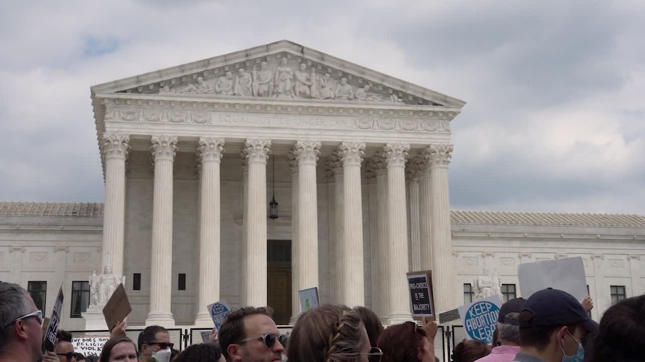 Supreme Court close up slow motion with crowd outside.