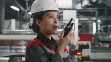 contratista femenina con radio en la fábrica