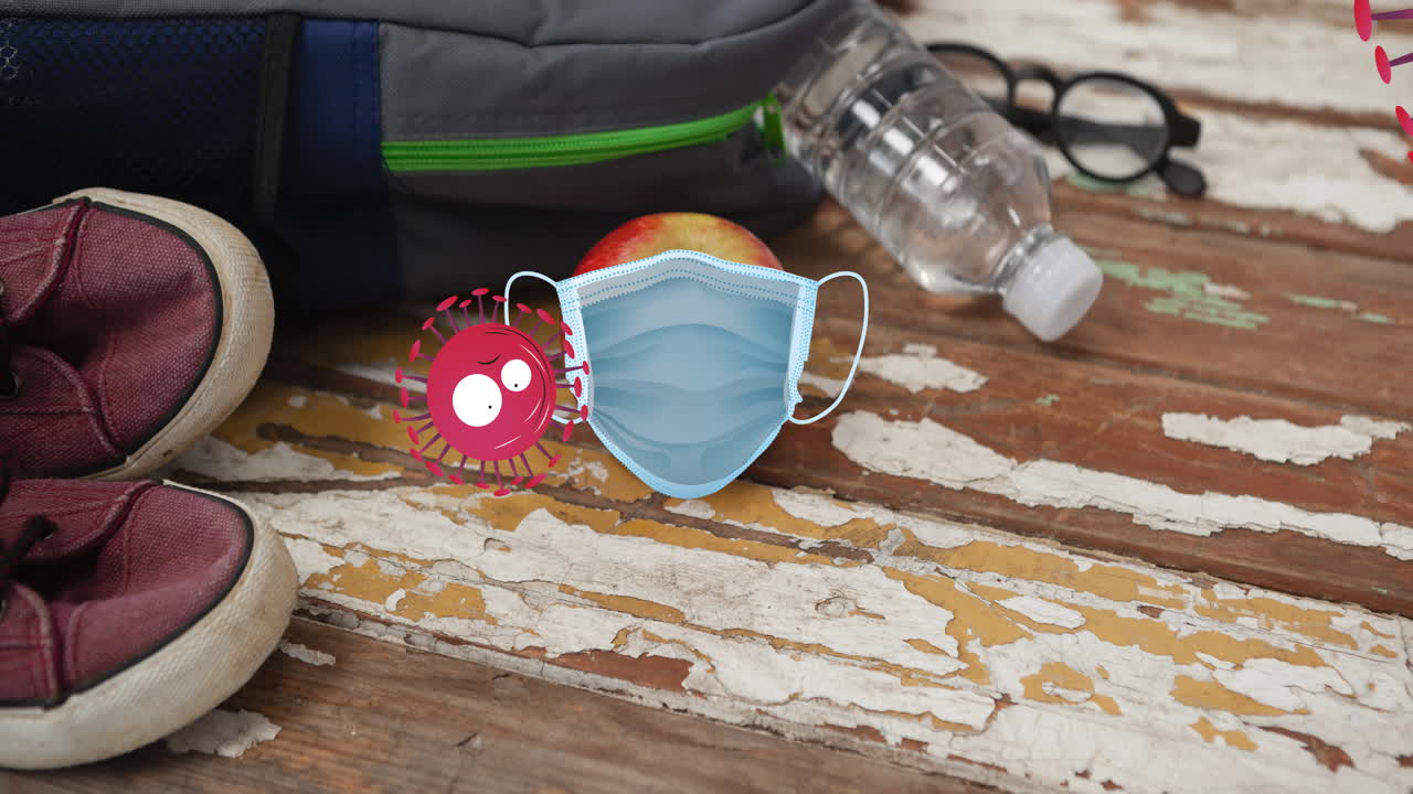 화가 난 코로나바이러스가 학교 책상 위에 있는 사과 위에 있는 마스크에 부 ⁇ 히는 애니메이션