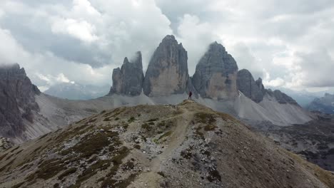 un hombre está disfrutando de la vista de tre cime di lavaredo en las dolomitas del norte de italia