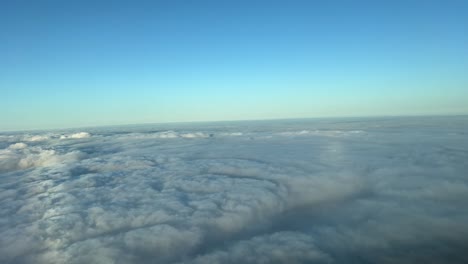 immersive pilot’s perspective in a real time flight over a blanket of clouds, as seen by the pilots during a right turn early in the morning