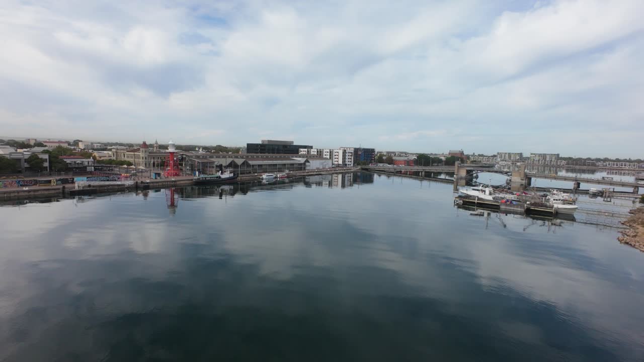 drone flight showing port Adelaide with the light house, draw bridge and boats with a boat yard behind them