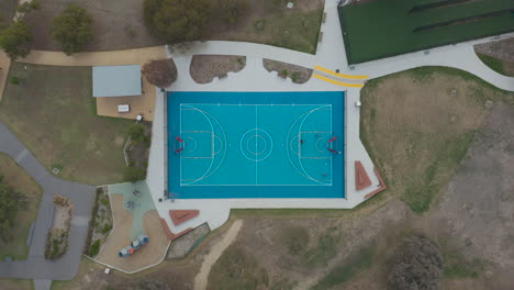 smooth decent on public sporting facilities while people play basketball at one end to maintain a healthy lifestyle