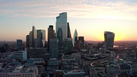 Kreisende-Luftdrohnenaufnahme-Von-Wolkenkratzergebäuden-Im-Zentrum-Von-London-Bei-Sonnenaufgang-Aus-Nächster-Nähe