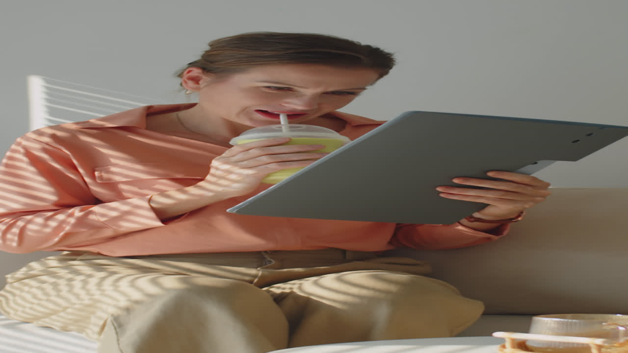 Middle-aged Businesswoman Drinking Smoothie and Reading Contract