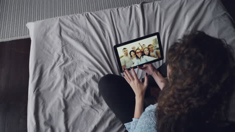 woman watching video call with friends on tablet