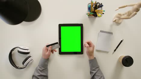 a finger touching a green screen of the tablet computer