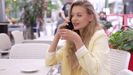 woman talking on phone in outdoor cafe